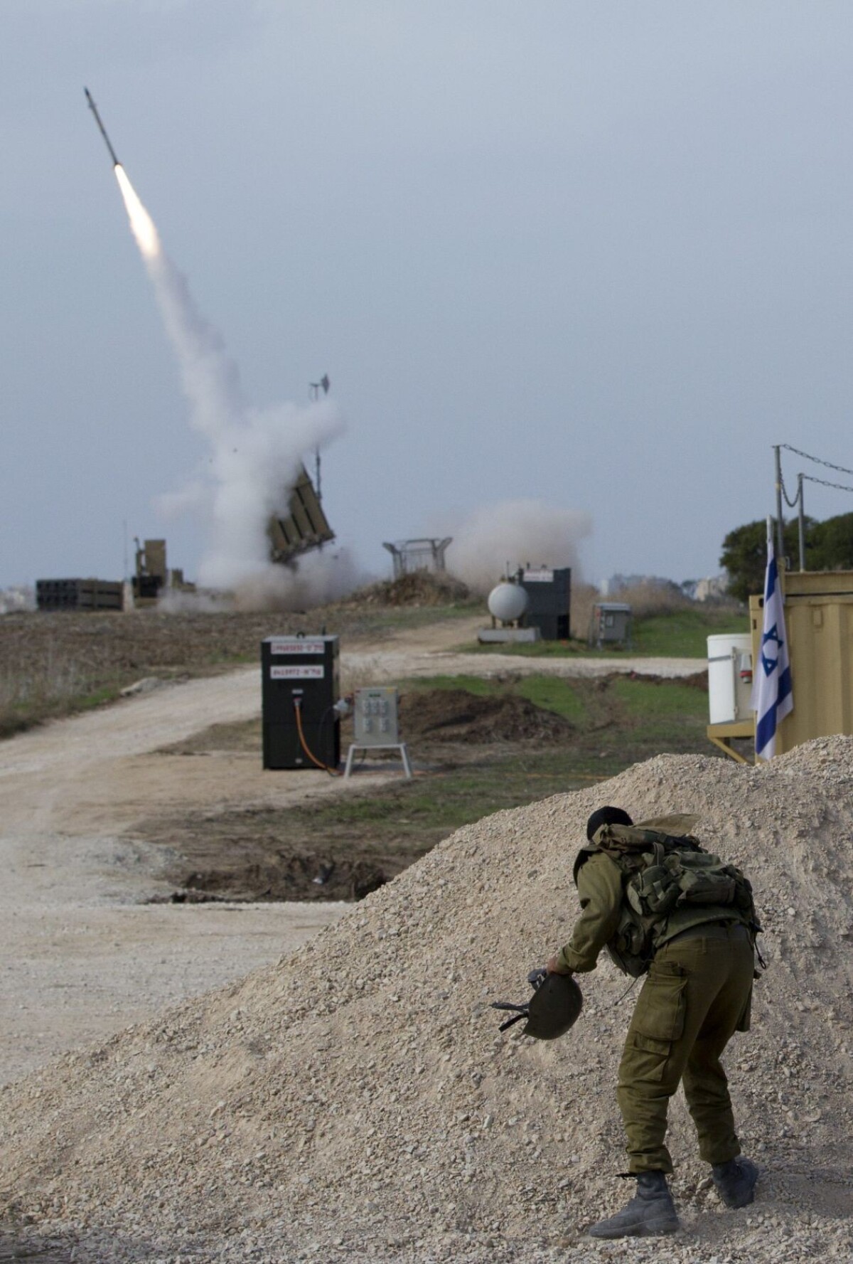 Izraelský vojak sleduje strelu zo systému protiraketovej obrany Železná kupola