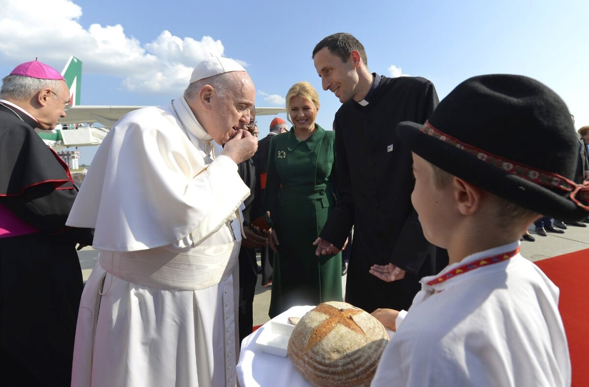 Pápež František ochutnáva chlieb a soľ.