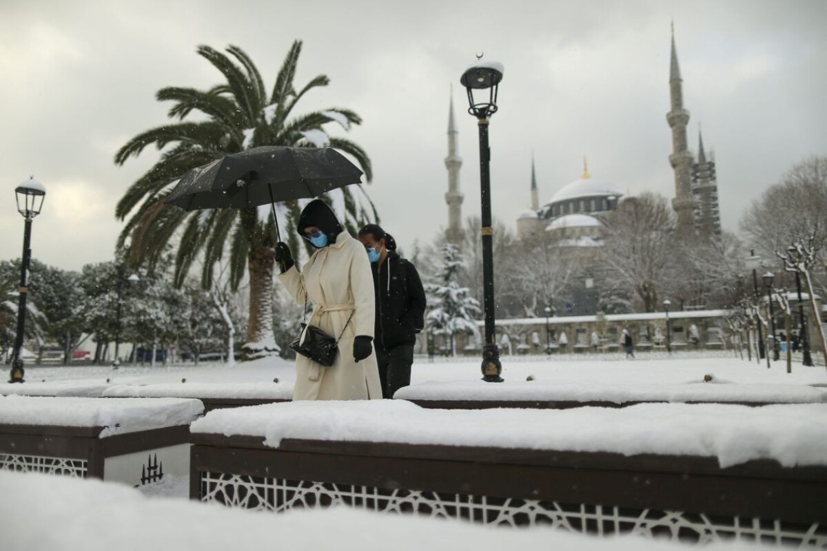 Ľudia kráčajú ulicami Istanbulu počas sneženia v pondelok 24. januára 2022.