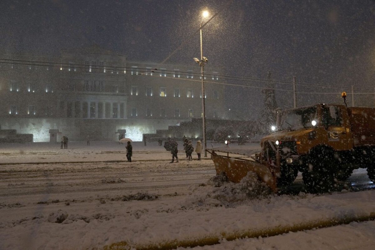 Snežný pluh odhŕňa sneh pred budovou parlamentu v Aténach počas hustého sneženia v pondelok 24. januára 2022.