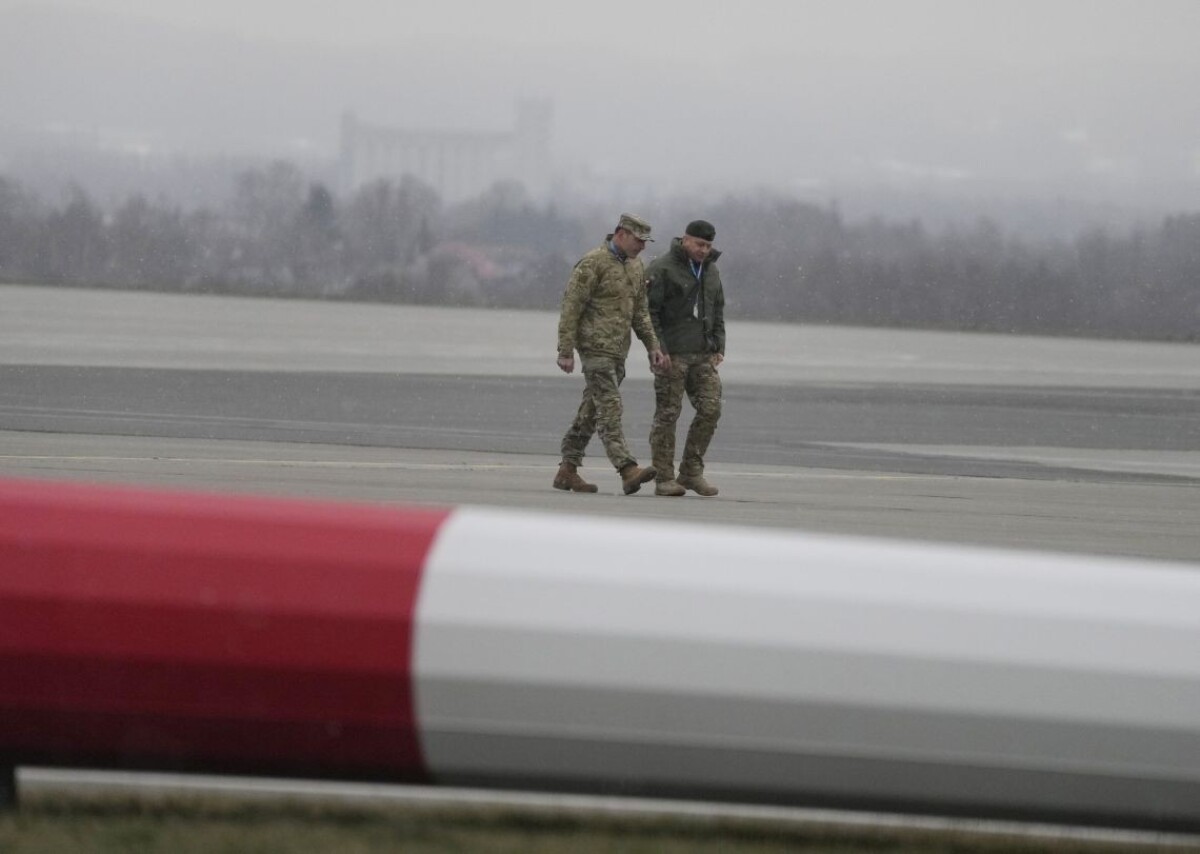 Poľskí a americkí vojenskí príslušníci sa rozprávajú po tom, ako americké jednotky vyložili vozidlá z dopravného lietadla po ich prílete z Fort Bragg na letisko Rzeszów-Jasionka  na juhovýchode Poľska 6.