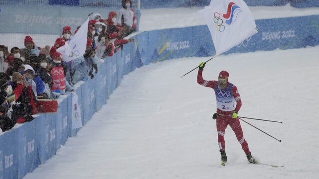 Bežec na lyžiach Ruského olympijského výboru (ROC) Sergej Usťugov drží vlajku ROC pred cieľom v nedeľnej štafete na 4x10 km v stredisku Čang-ťia-kchou na ZOH 2022 v Pekingu v nedeľu 13. februára 2022.