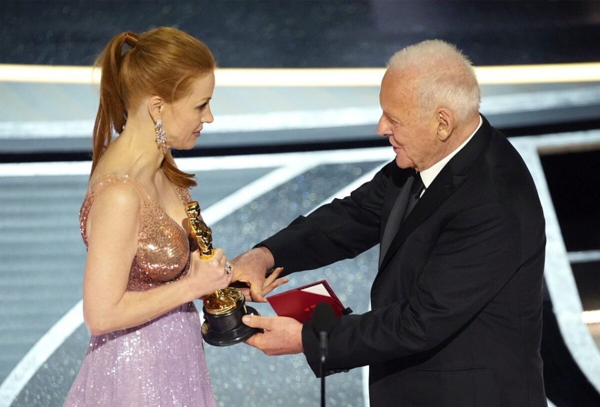 Jessica Chastainová si preberá z rúk Anthonyho Hopkinsa sošku Oscara.