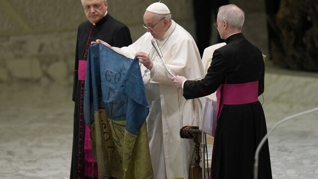 Pápež František ukazuje ukrajinskú zástavu, ktorú mu poslali z mesta Buča.