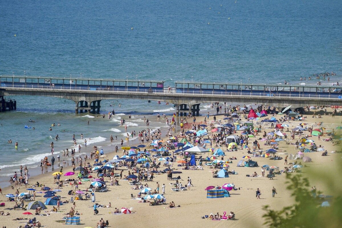 Ľudia si užívajú more a pláž v meste Bournemouth.