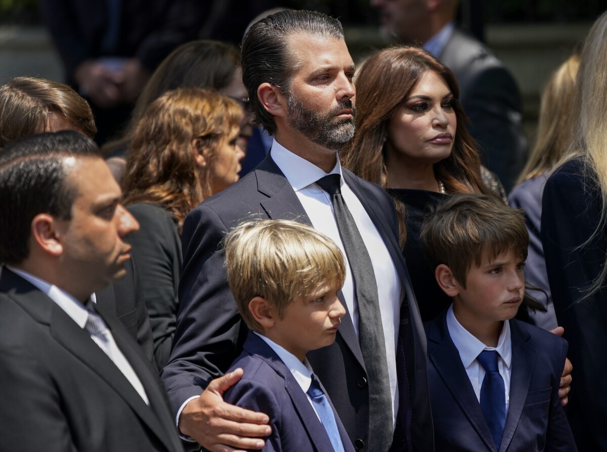 Donald Trump Jr., uprostred, sleduje s dvoma svojimi synmi, ako nosiči nesp rakvu jeho matky.