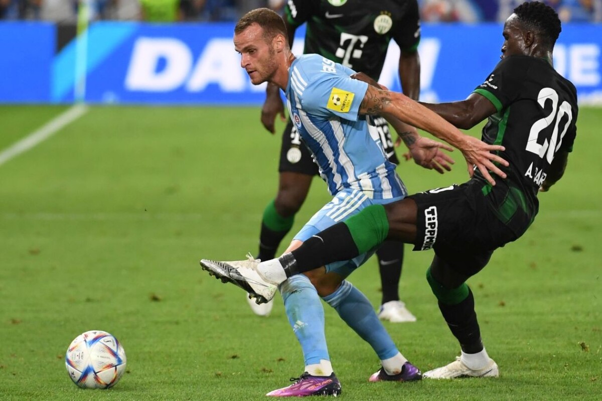 Futbalista Slovana Lukáš Pauschek a hráč Ferencvárosu Adama Traore bojujú o loptu