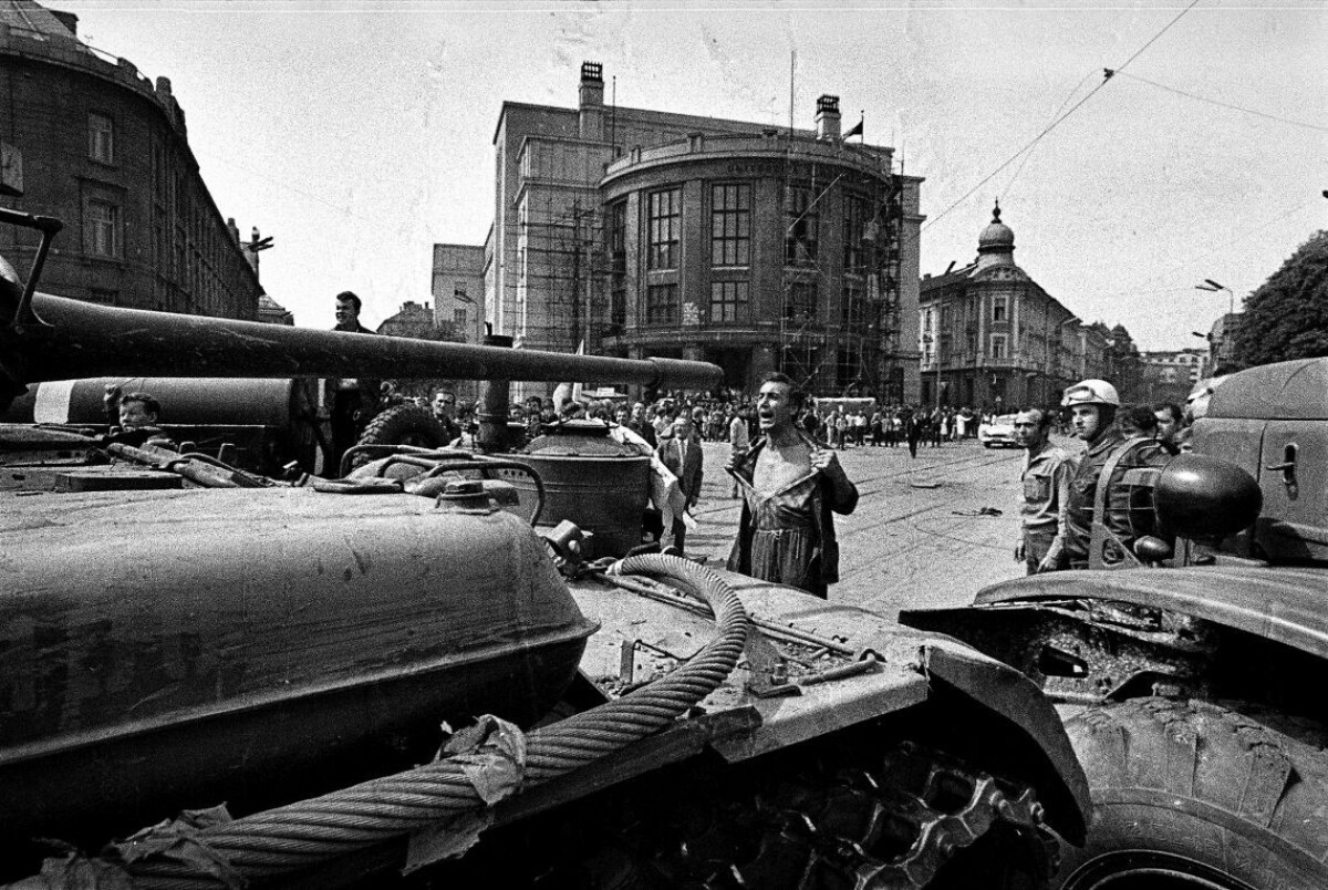 Muž s odhalenou hruďou pred okupačným tankom