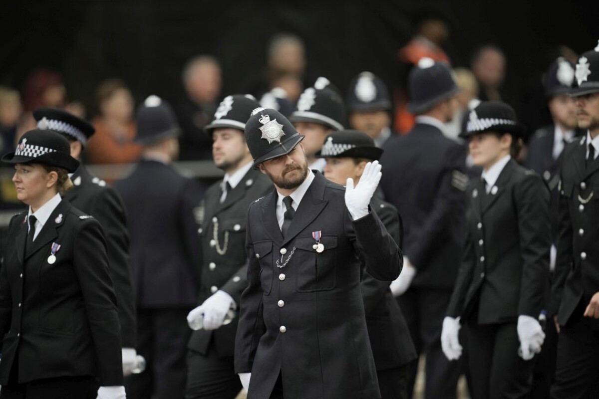 Policajt máva okoloidúcim pri prechádzke po The Mall skoro ráno pred pohrebným sprievodom kráľovnej Alžbety II