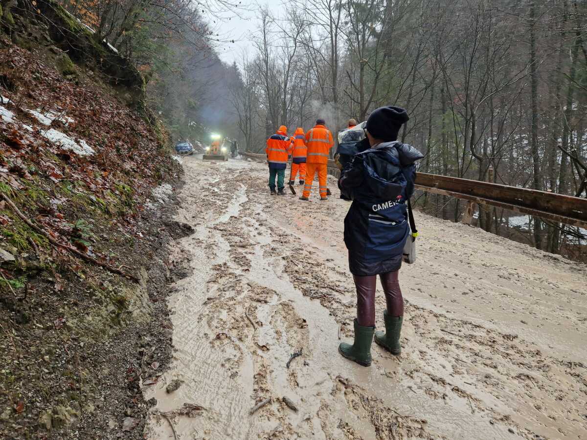 Cestári odstraňujú z cesty bahno a kal.