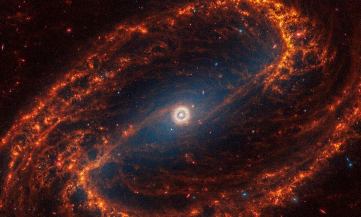 Špirálová galaxia NGC 1300 s priečkou s malými červenými hviezdami.