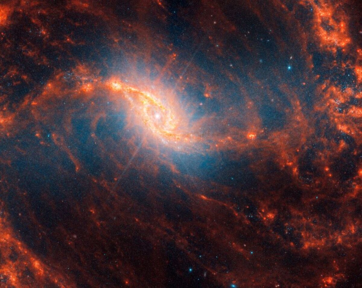 Špirálová galaxia NGC 1365 s ružovými difrakčnými hrotmi, ktoré by mohli naznačovať aktívnu supermasívnu čiernu dieru v srdci tejto galaxie.