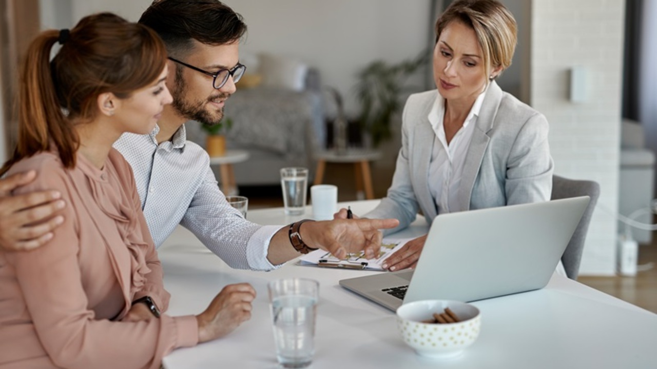 young-couple-real-estate-agent-using-laptop-while-having-meeting-office.jpg
