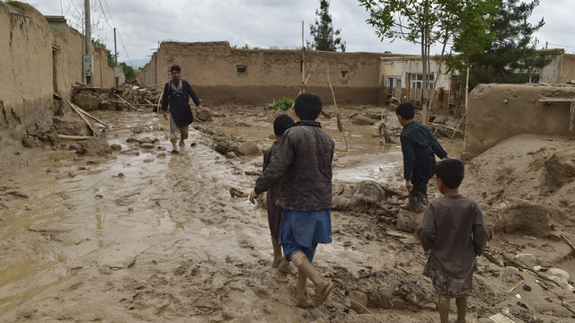 Ľudia kráčajú okolo svojich zničených domov po silných záplavách v provincii Baglán na severe Afganistanu 