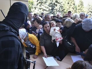  Evakuovali ľudí v regióne Kursk v rade na vyplnenie formulára na humanitárnu pomoc v stredisku distribúcie humanitárnej pomoci v Kursku, Rusko , streda 14. augusta 2024.