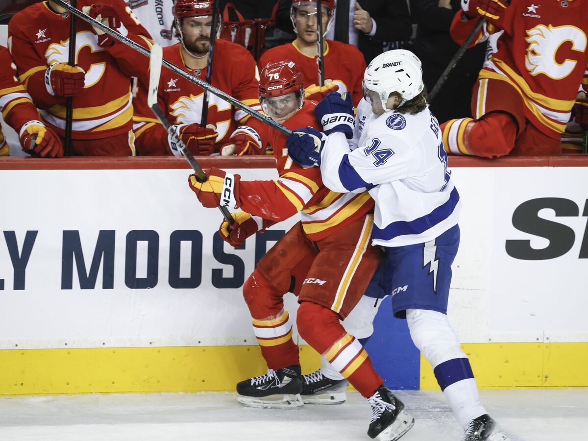 Conor Geekie z Tampy Bay Lightning (vpravo) udrel Martina Pospíšila z Calgary Flames