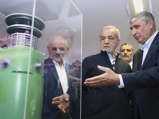 Iránsky prezident Masúd Pezeshkian (druhý sprava) počúva šéfa Iránskej organizácie pre atómovú energiu Mohammada Eslamiho počas návštevy výstavy iránskych jadrových úspechov v Teheráne v apríli 2025.