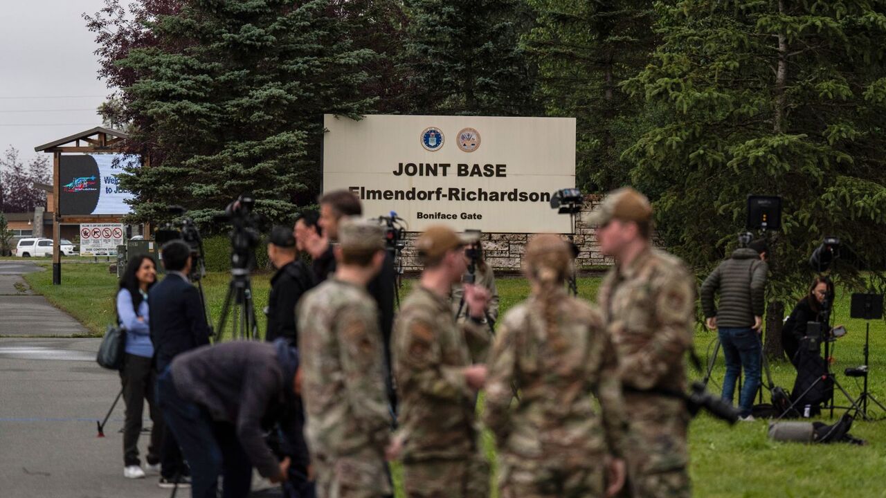 Vojenský personál a médiá stoja pred spoločnou základňou Elmendorf-Richardson v Anchorage na Aljaške vo štvrtok 14. augusta 2025 pred stretnutím prezidenta Donalda Trumpa a ruského prezidenta Vladimira Putina.