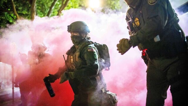 Policajti a federálni agenti hádžu slzotvorné granáty, aby rozohnali demonštrantov v blízkosti zariadenia amerického imigračného a colného úradu v Portlande v štáte Oregon v nedeľu 5. októbra 2025.