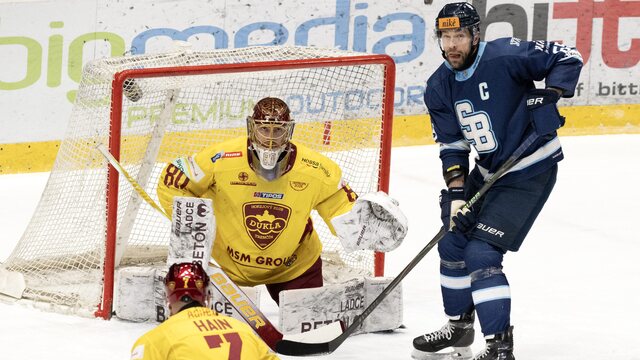 Tomáš Marcinko (Slovan) a brankár Julian Junca (Trenčín) počas zápasu 51. kola Tipsport ligy HC Slovan Bratislava - HK Dukla Trenčín 