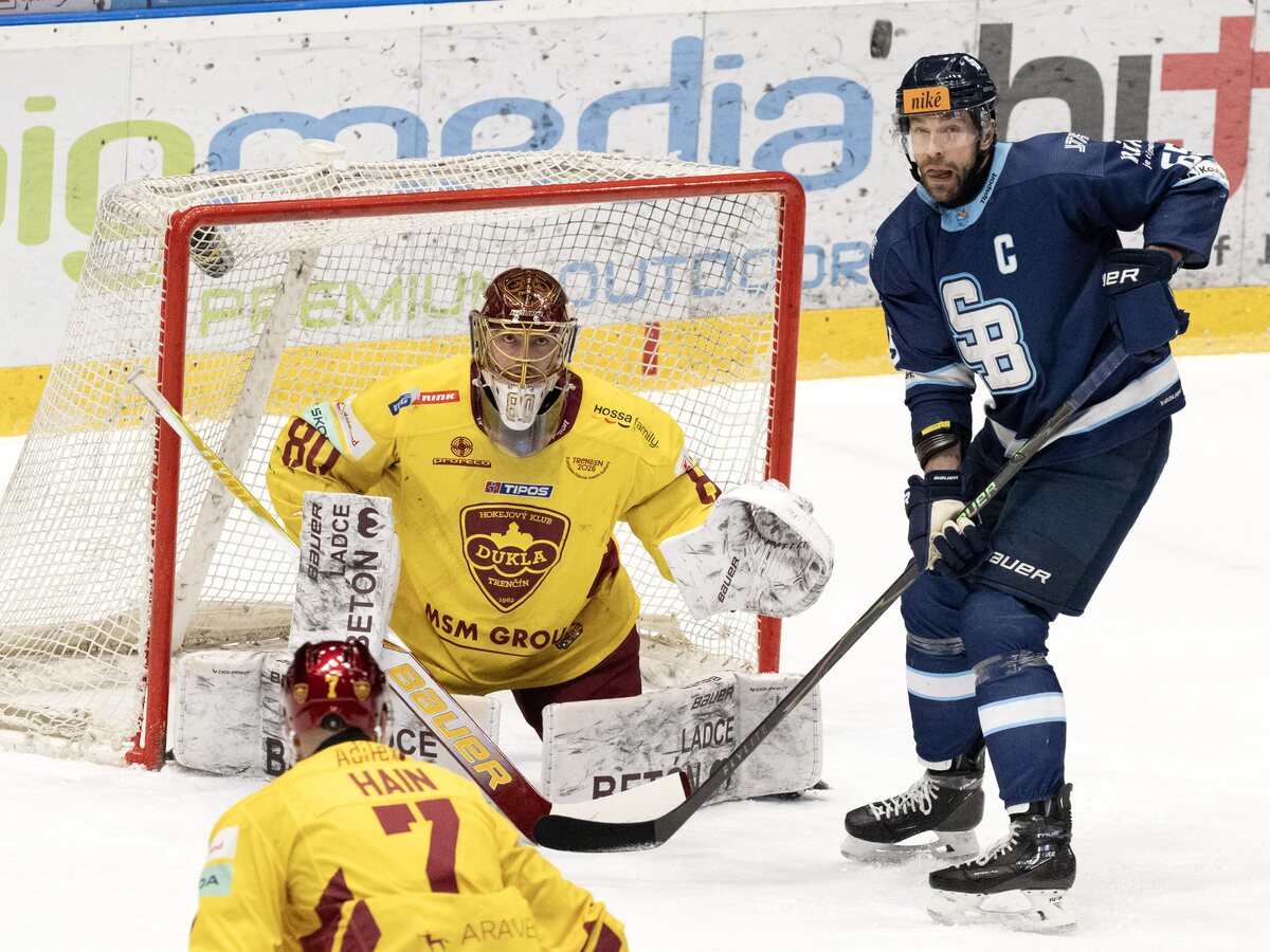 Tomáš Marcinko (Slovan) a brankár Julian Junca (Trenčín) počas zápasu 51. kola Tipsport ligy HC Slovan Bratislava - HK Dukla Trenčín 
