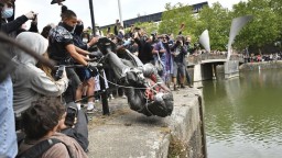 Rozvášnení protestujúci strhli a hodili do vody sochu otrokára