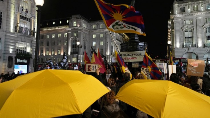 Protestujúci mávajú vlajkami počas malej demonštrácie proti konaniu ZOH 2022 v Pekingu v Londýne vo februári 2022.